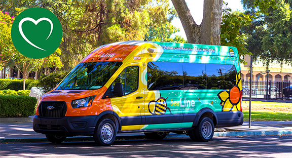 BeeLine microtransit vehicle parked under trees